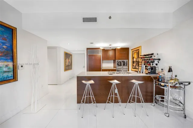 a large kitchen with stainless steel appliances a sink and cabinets