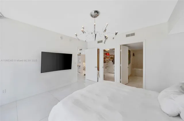 a bedroom with a bed a couch and large window