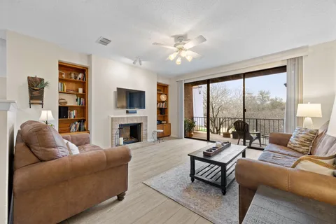 a living room with furniture a large window and a fireplace