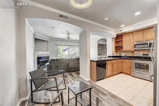 a kitchen with stainless steel appliances granite countertop a stove top oven a sink a counter space and cabinets