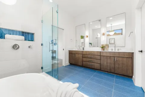 a en suite bathroom with a double vanity sink a mirror and shower