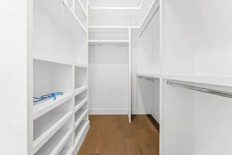 a view of walk in closet with empty racks