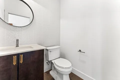 a white toilet sitting next to a bathroom sink