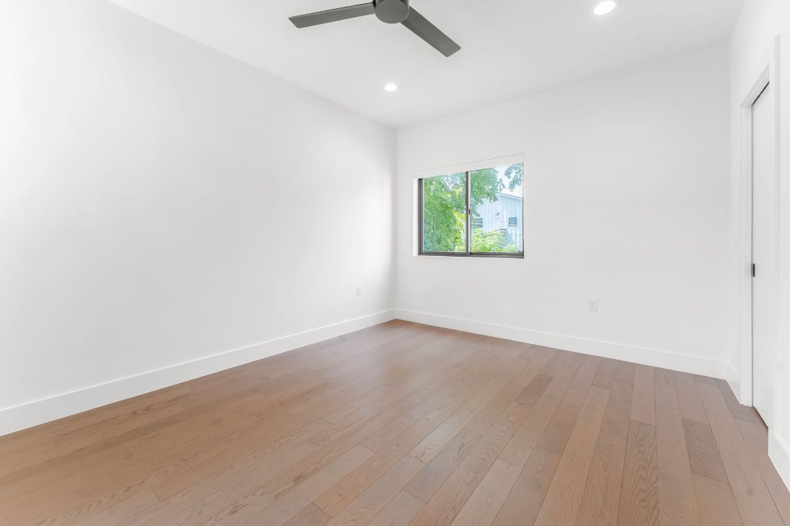 205 Ben Howell Drive Austin, TX 78704 - Photo 29 of 38 an empty room with wooden floor chandelier fan and windows
