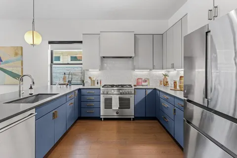 a kitchen with stainless steel appliances granite countertop a sink stove and refrigerator