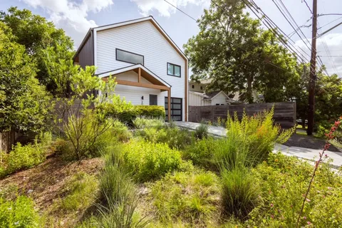 a view of a house with pool plants and large trees
