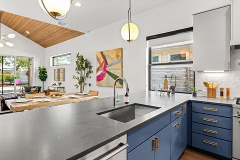 a kitchen with sink and view of living room