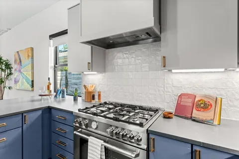 a stove top oven sitting inside of a kitchen