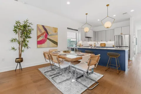 a living room with dining table and a chandelier