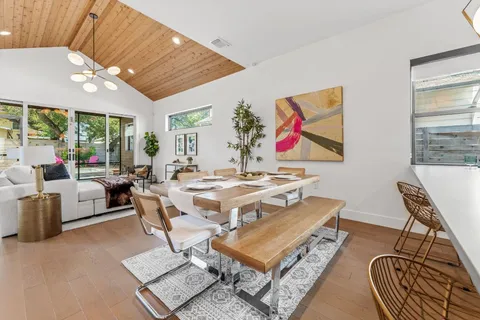 a living room with furniture a rug and a floor to ceiling window