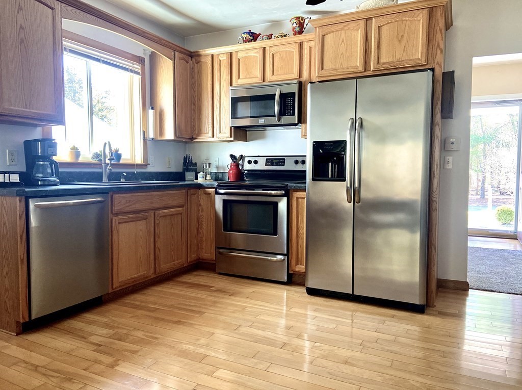 48 Pine Street Rochester, MA 02770 - Photo 19 of 39 a kitchen with stainless steel appliances granite countertop a refrigerator a stove a sink and dishwasher with wooden floor