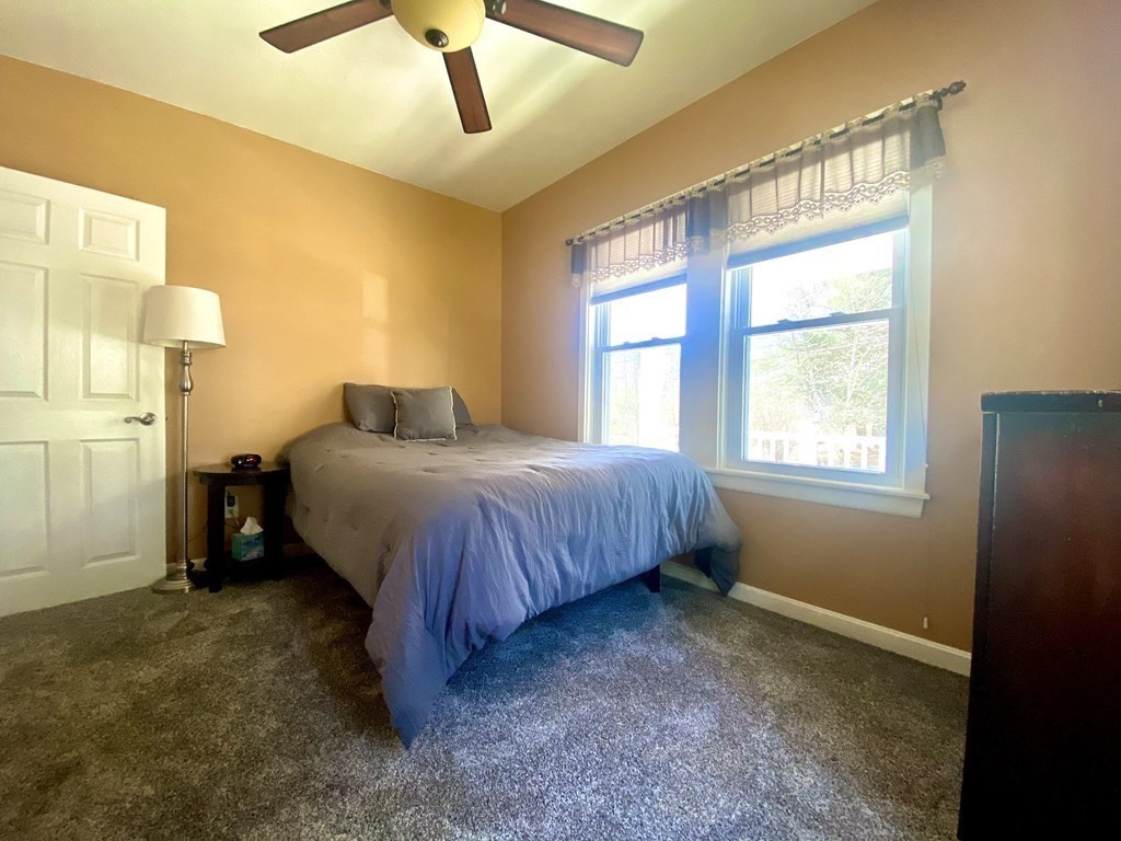 48 Pine Street Rochester, MA 02770 - Photo 26 of 39 a bedroom with a bed and a chandelier
