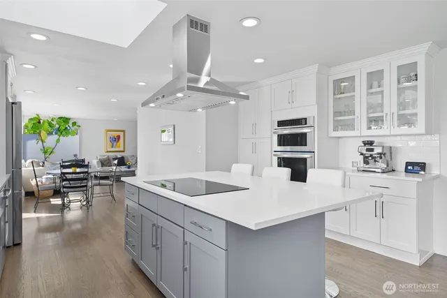 a kitchen with counter top space sink stove and wooden floor
