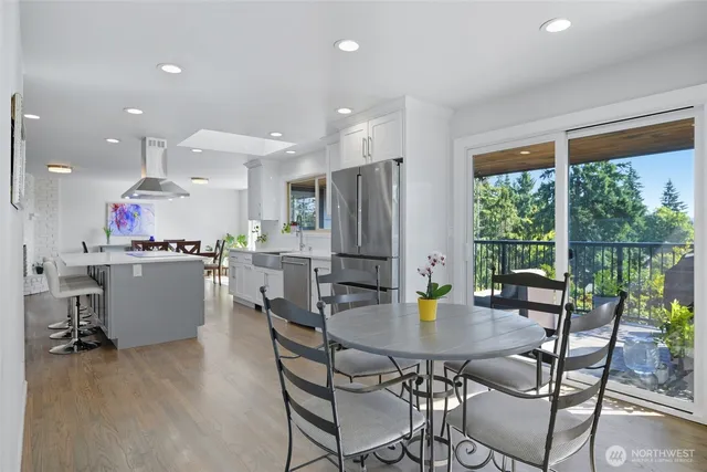 a kitchen with a table chairs and flat screen tv