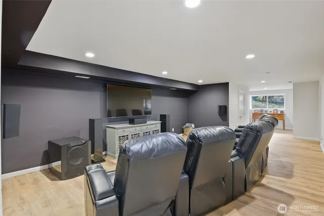 a living room with furniture a flat screen tv and kitchen view