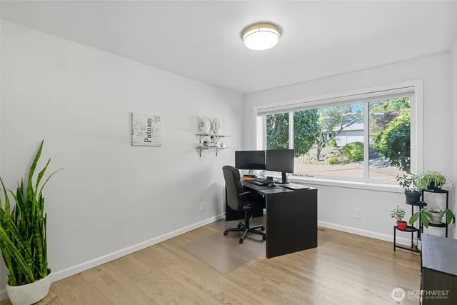 a view of a workspace with furniture and a window