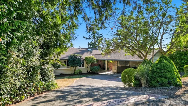 a front view of a house with a yard and tree s