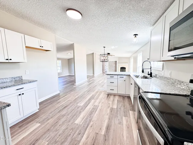 a large kitchen with a lot of counter space and wooden floor