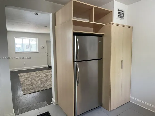 a view of kitchen with stainless steel appliances wooden floor and cabinet