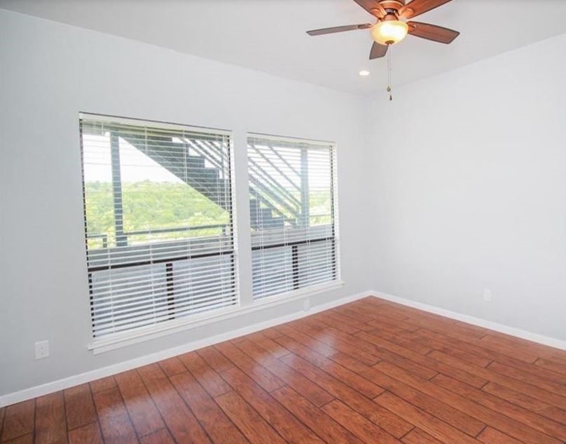 2612 San Pedro Street, Unit 116 Austin, TX 78705 - Photo 13 of 20 an empty room with wooden floor fan and windows
