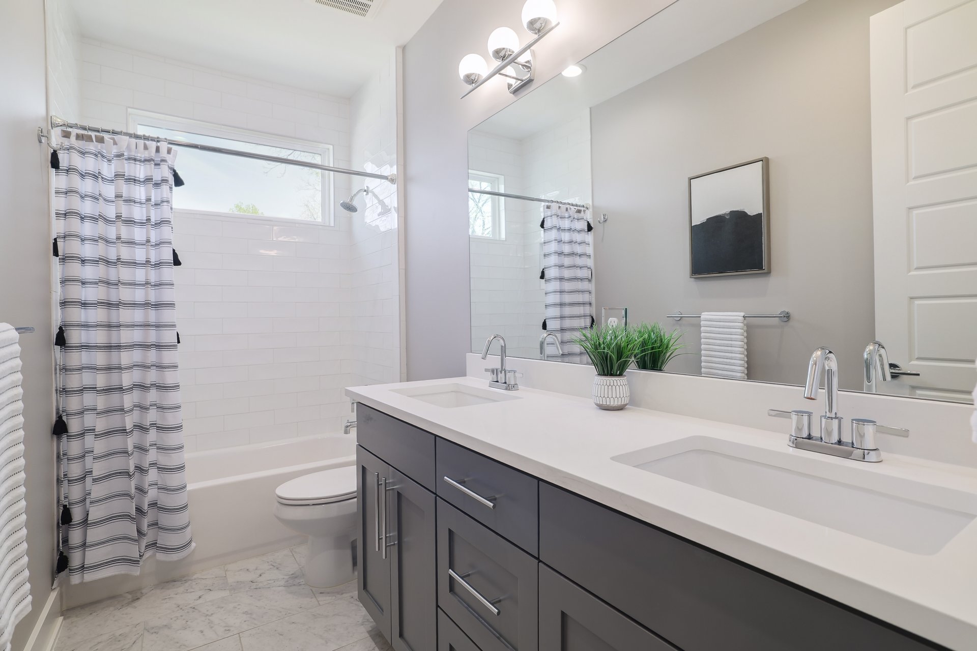 1103 Saucedo Street, Unit B Austin, TX 78721 - Photo 19 of 26 The secondary bathroom maintains the home’s updated aesthetic with a large dual vanity and neutral finishes