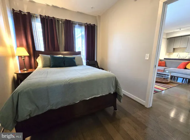 a bedroom with a bed closet and wooden floor