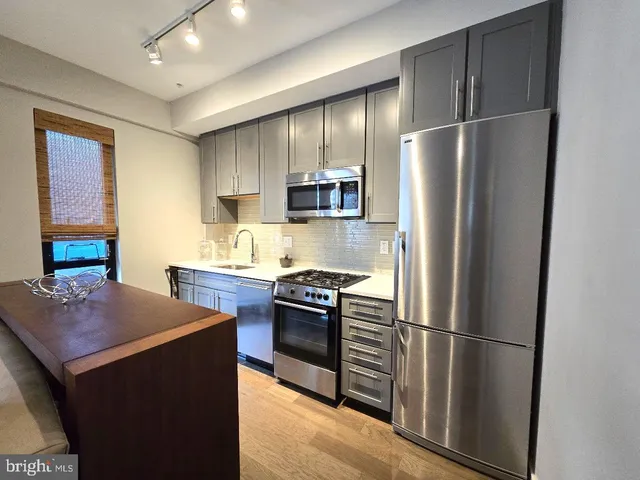 a kitchen with stainless steel appliances granite countertop a refrigerator and a stove