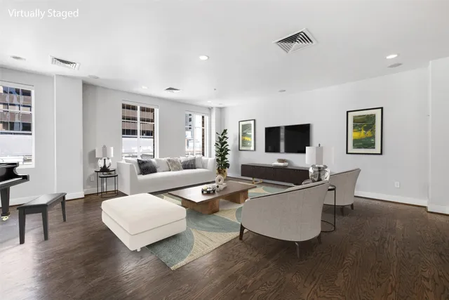 a living room with furniture flat screen tv and wooden floor