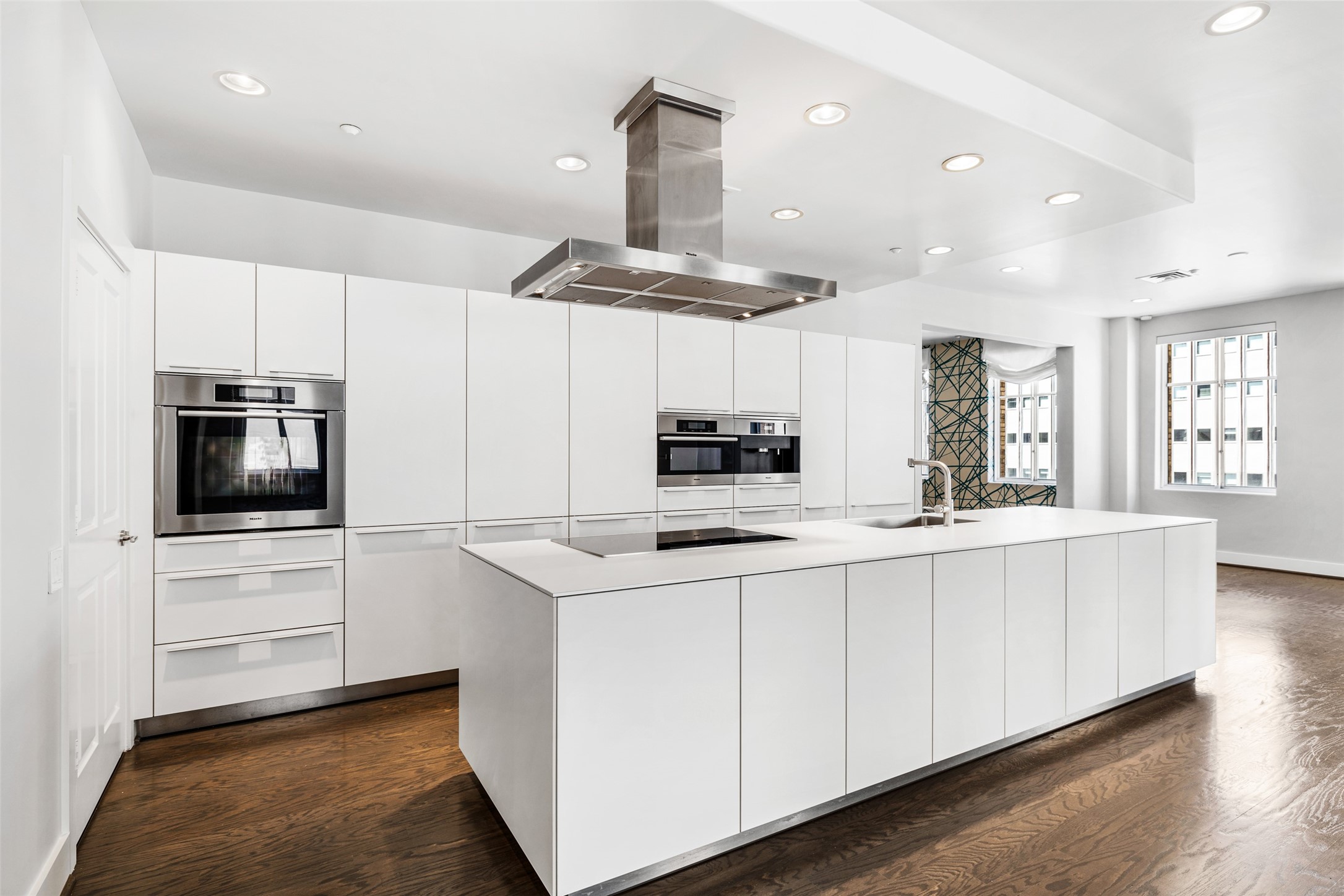 914 Main Street, Unit 1201 Houston, TX 77002 - Photo 13 of 36 a kitchen with stainless steel appliances a sink a stove a microwave a center island and cabinets