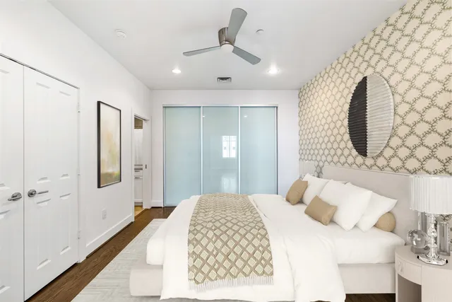 a bedroom with a large bed and a chandelier