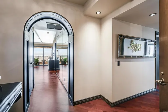 a view of a hallway with wooden floor and a living room