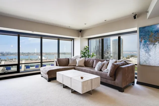 a living room with furniture and large windows