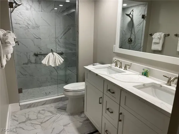 a bathroom with a shower a toilet and sink