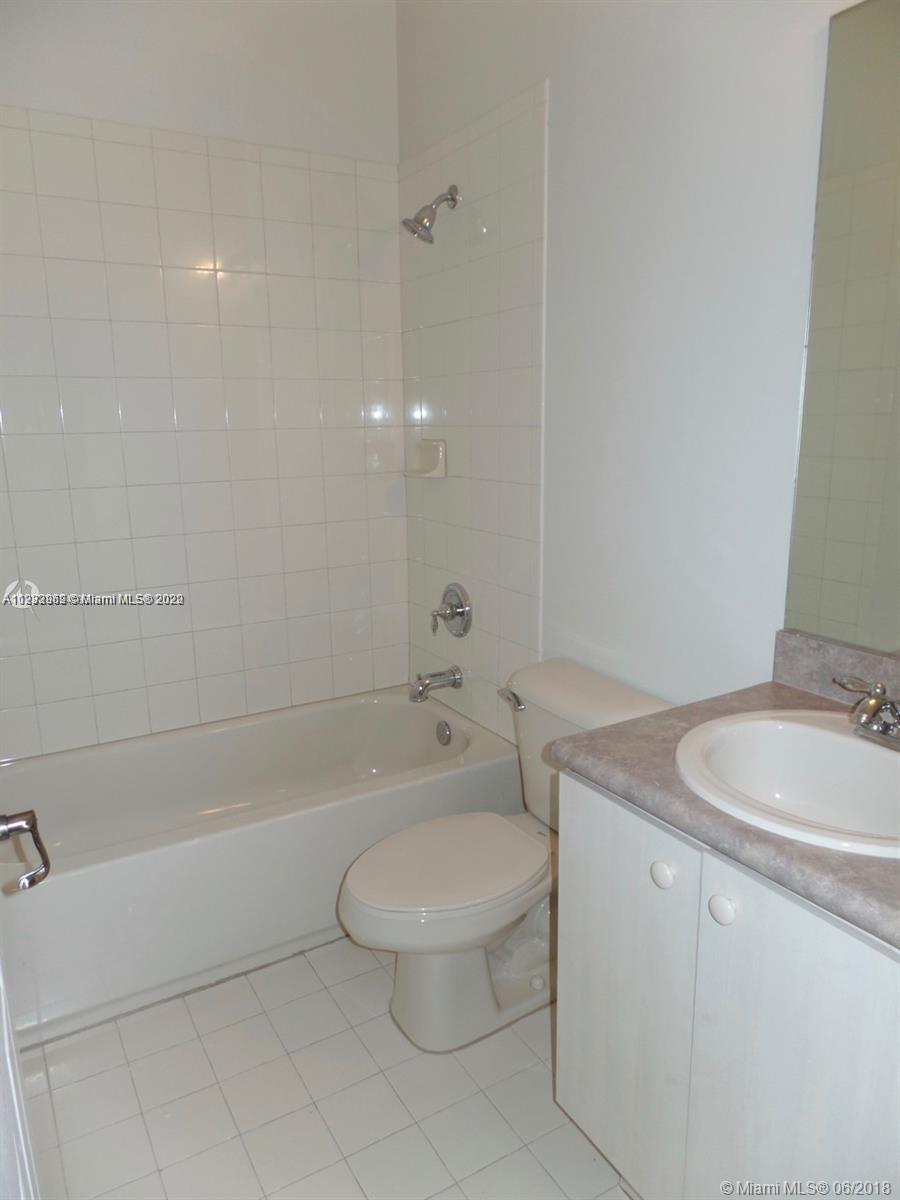 14055 Southwest 49th Street, Unit 6 Miramar, FL 33027 - Photo 8 of 12 a bathroom with a granite countertop toilet a sink and bathtub