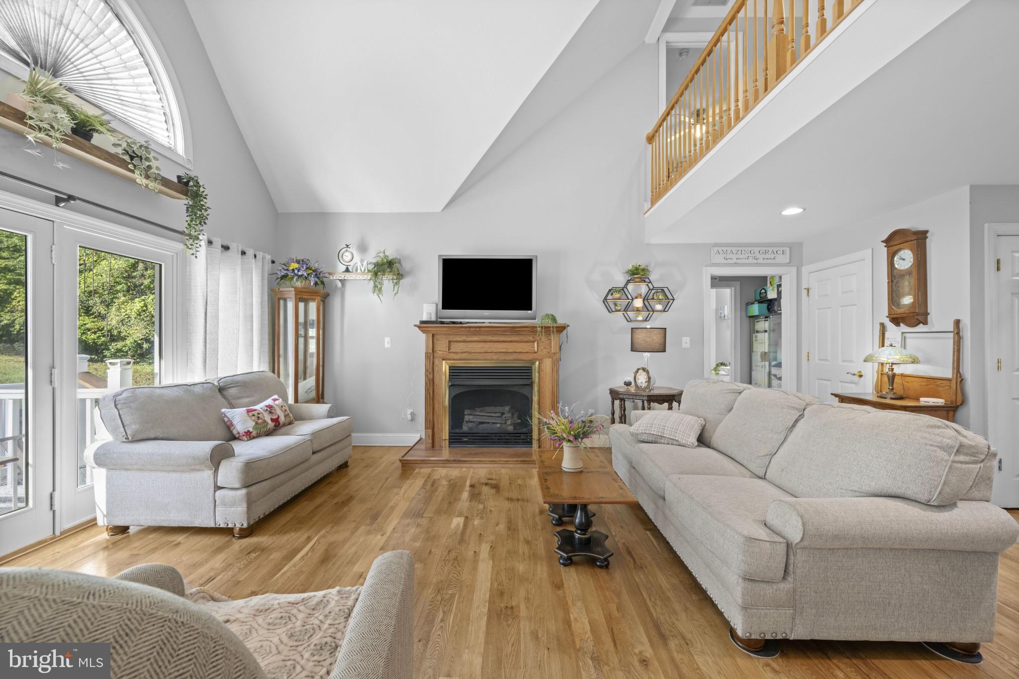 194 Cook Road Delta, PA 17314 - Photo 12 of 35 a living room with furniture a fireplace a flat screen tv and a large window