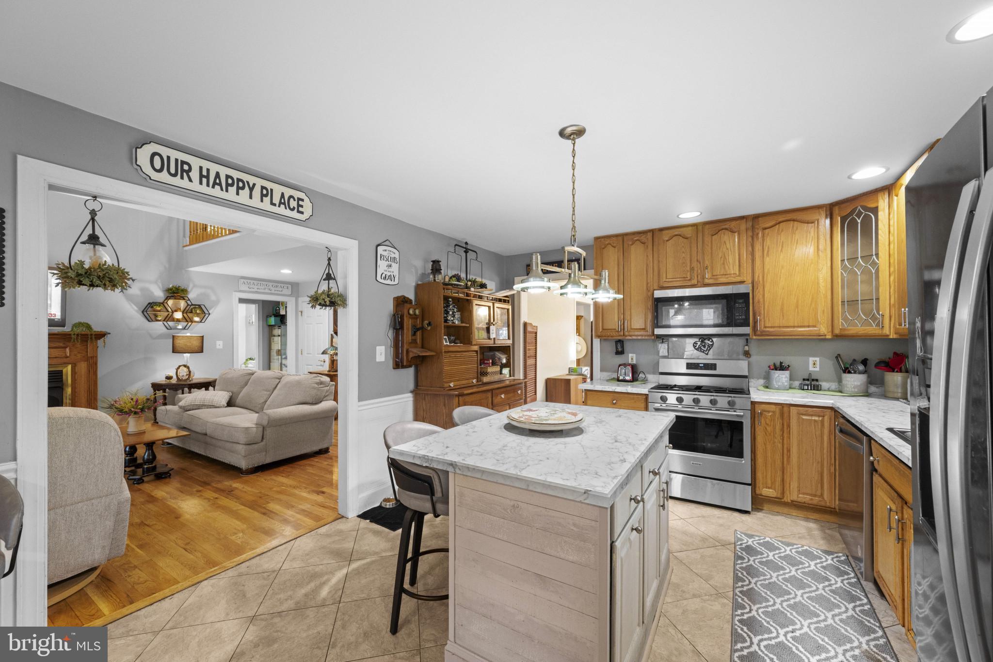 194 Cook Road Delta, PA 17314 - Photo 14 of 35 a kitchen with stainless steel appliances kitchen island granite countertop a refrigerator a stove top oven a sink dishwasher a dining table and chairs with wooden floor