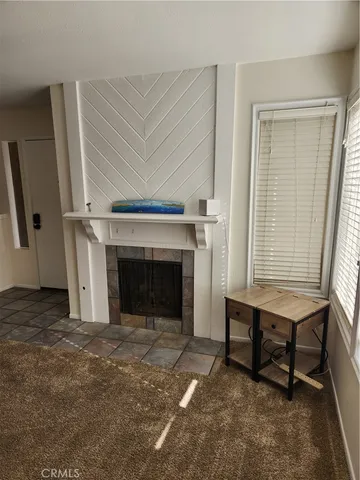 a view of an empty room with window and a fireplace