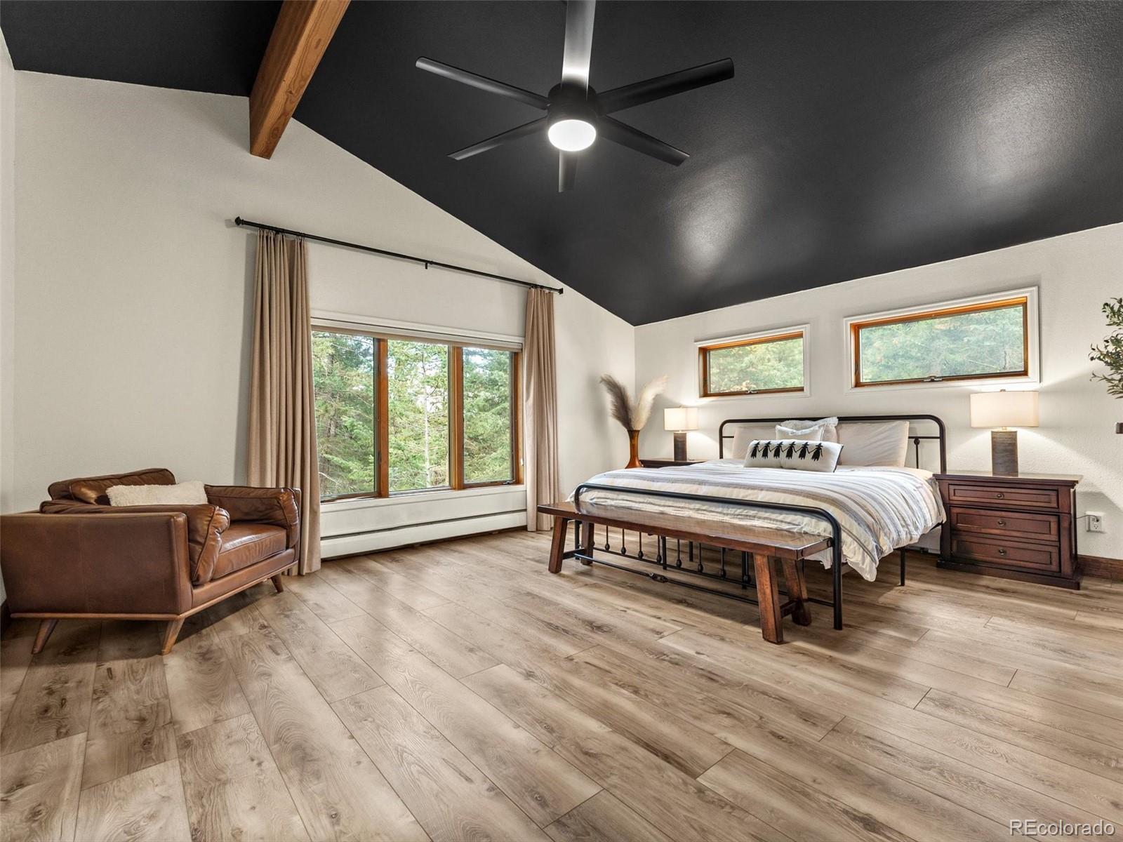 9459 South Turkey Creek Road Morrison, CO 80465 - Photo 12 of 25 a spacious bedroom with a bed and large windows