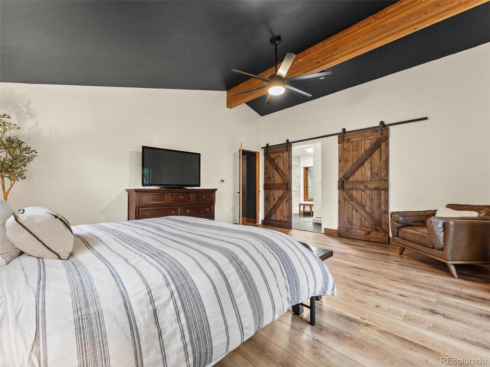 9459 South Turkey Creek Road Morrison, CO 80465 - Photo 13 of 25 a bedroom with a bed and wooden floor