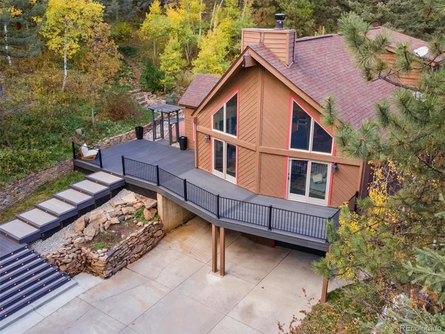 a view of a house with a yard balcony and wooden fence