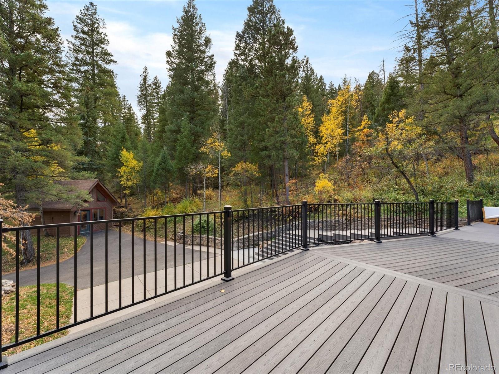 9459 South Turkey Creek Road Morrison, CO 80465 - Photo 2 of 25 a view of a wooden deck with trees