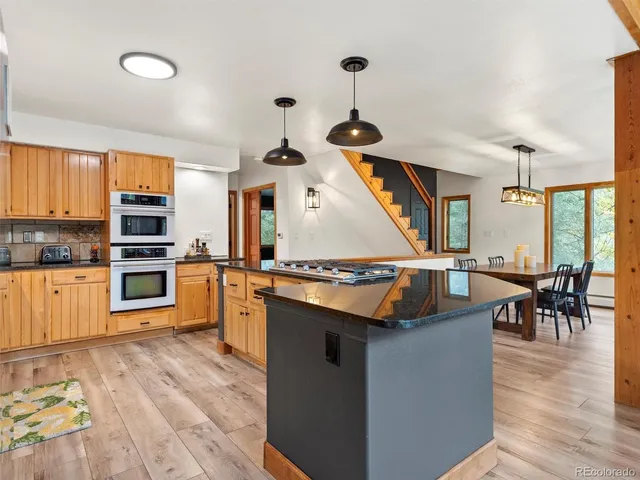 a kitchen with stainless steel appliances granite countertop a stove and a wooden floors