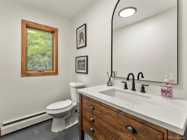 a bathroom with a toilet sink and mirror