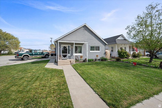311 East Factory Street Garland, UT 84312 - Photo 1 of 1 View of front of house with a porch and a front lawn with side parking