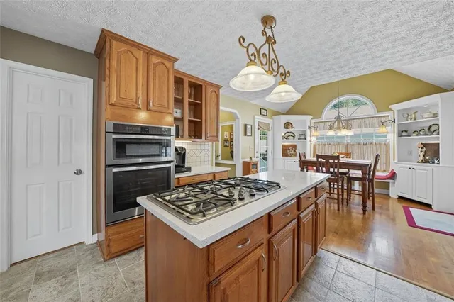 a kitchen with a stove a table and chairs