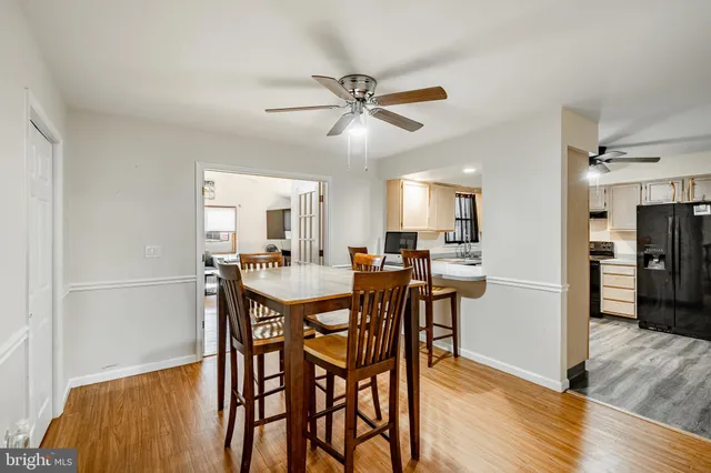 a kitchen with a refrigerator a sink and dishwasher with wooden floor