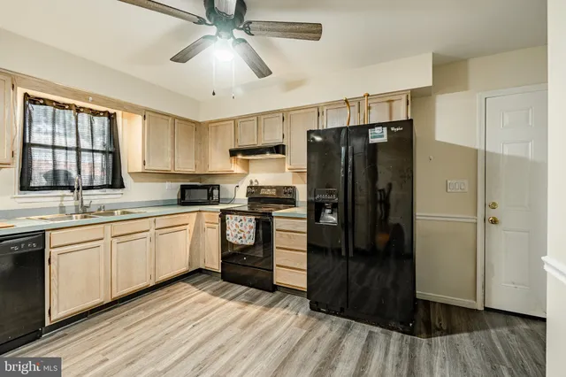 a kitchen with stainless steel appliances granite countertop a refrigerator sink and stove