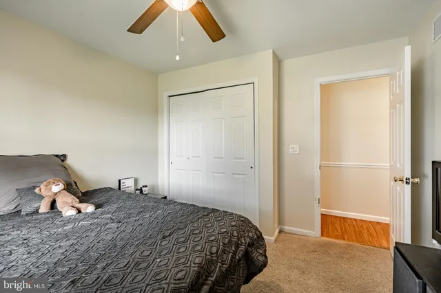a spacious bedroom with a bed and painting on the wall