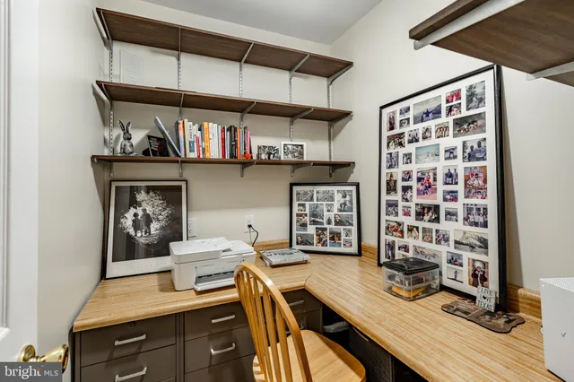a view of a hallway with wooden floor and a bathroom
