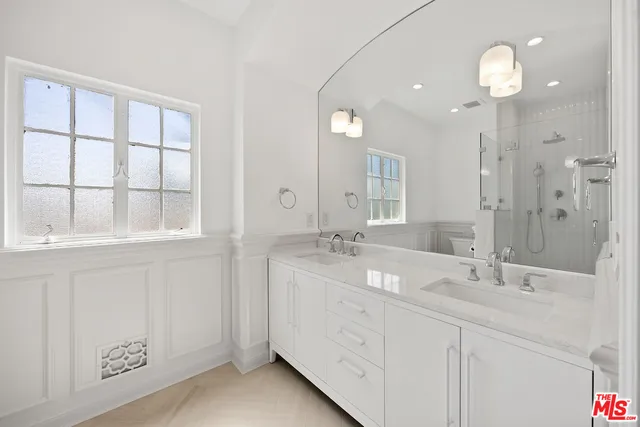 a bathroom with a double vanity sink and a mirror